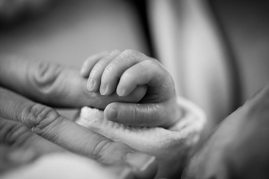 grayscale-photography-of-baby-holding-finger-2081891