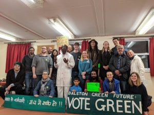 A group of people stand together with a banner that reads 'Dalston green futures. Vote green'
