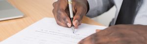 An image of a person holding a pen and writing